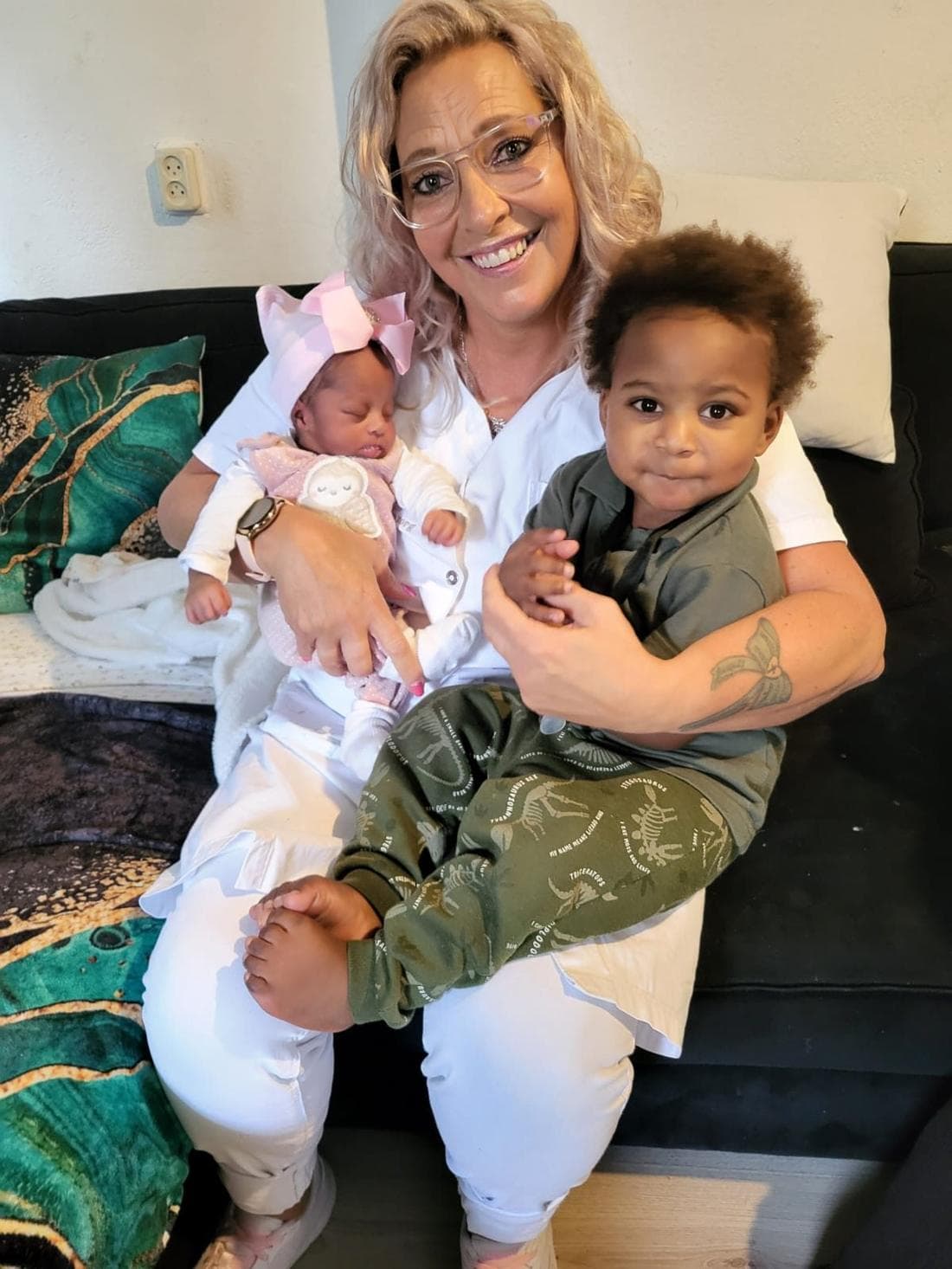 Cindy lachend met een pasgeboren baby op de arm in een warme huiselijke setting